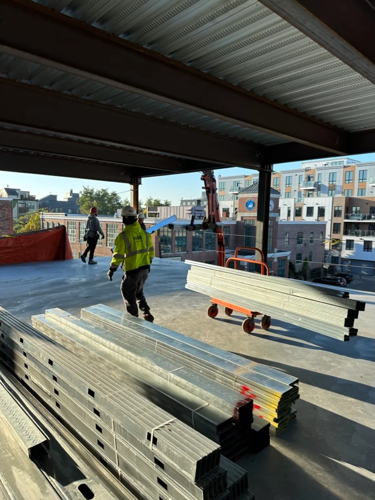 Telehandler delivering drywall boards to an upper floor at 33A Street, South Boston